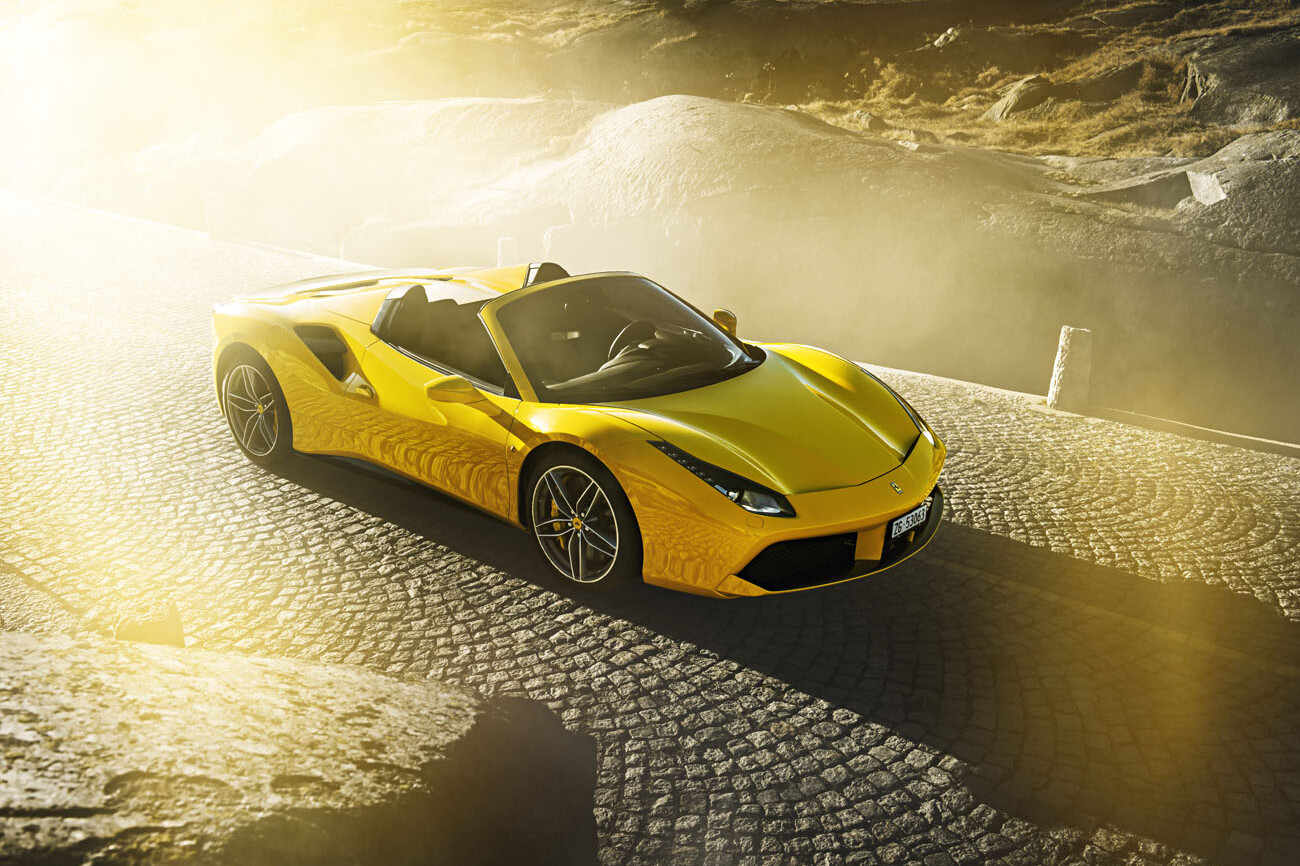 Im morgendlichen Sonnenlicht glänzt der Ferrari 488 Spider. Foto entstand auf dem Gotthard Pass in den Schweizer Alpen.