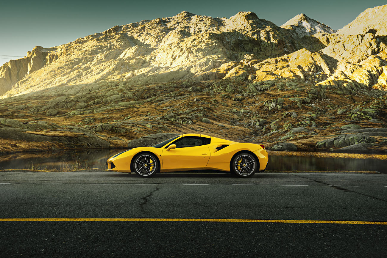 Auto Bilder von phPics. Der gelbe Ferrari 488 steht in der Schweiz auf dem Gotthardpass.