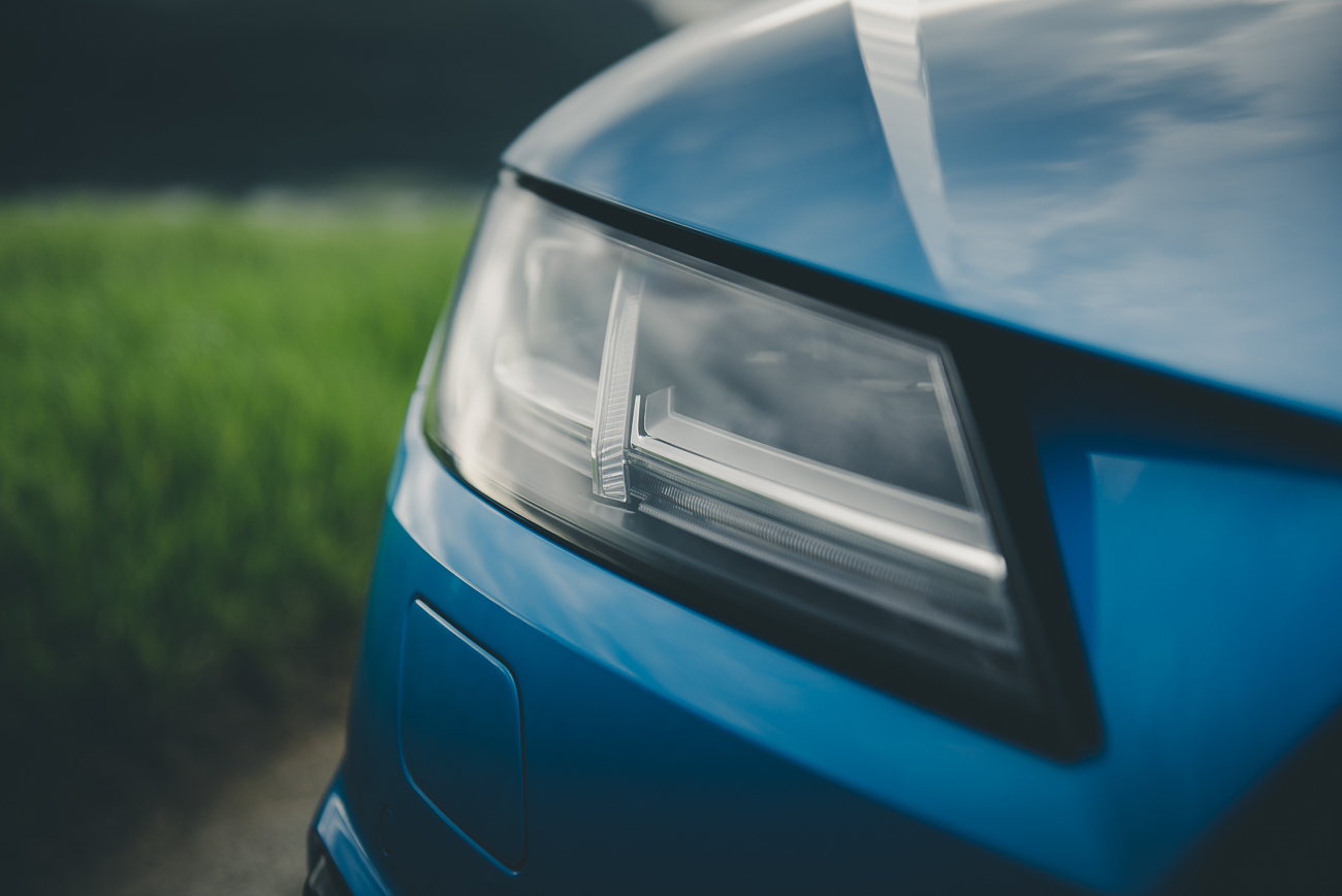 Detailansicht des Frontscheinwerfers vom turboblauen Audi TT..