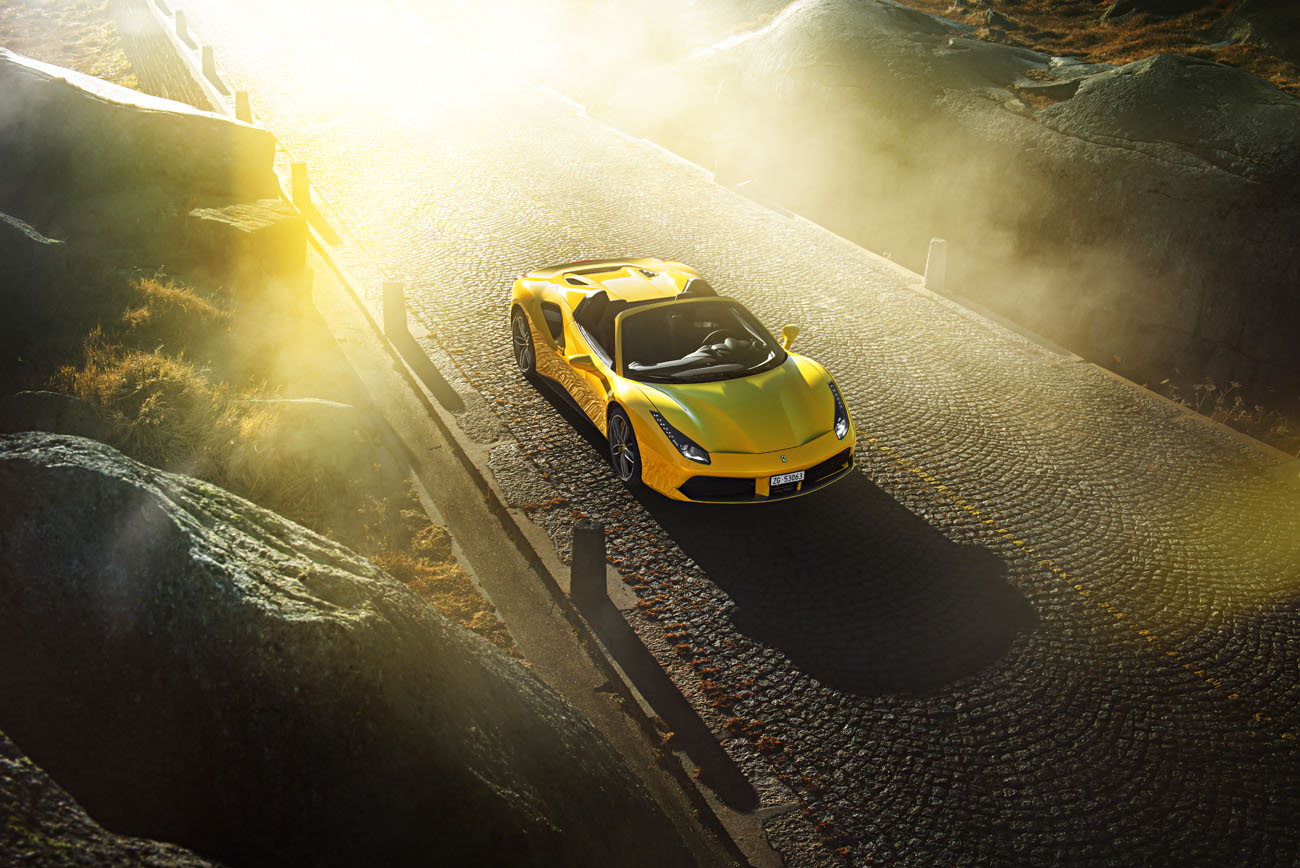 Sonnenaufgang auf der Tremola beim Gotthard-Pass mit einem Ferrari Cabriolet.