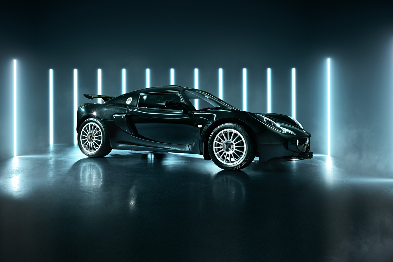 Ein schwarzer Lotus Exige vor Leuchtstoffröhren.